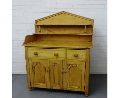 An antique pine ledgeback dresser with a shelf back over a rectangular top with a single long and short drawer over three cup