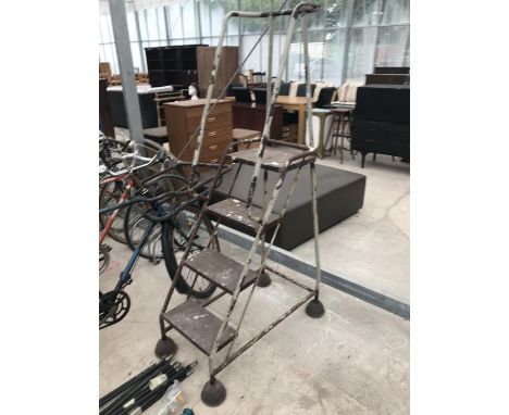A METAL FOUR STEP PLATFORM/AUCTIONEERS STEPS ON WHEELS 