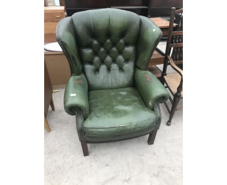 A GREEN LEATHER WING AND BUTTON BACK ARMCHAIR 