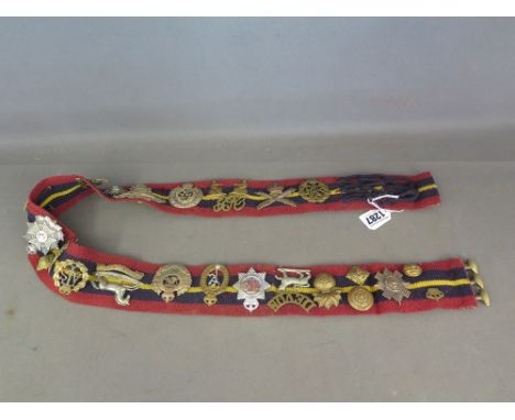 A military barrack dress belt set with 27 cap badges, buttons and collar flashes etc including Machine Gun Corps 3rd Kings Ow