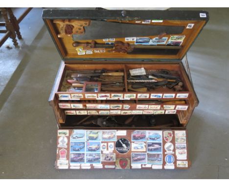 A vintage tool chest with lift up top and drop front revealing three internal drawers with contents of woodworking tools incl