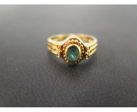 An ancient style 22 carat gold ring set with an oval emerald, collet set with bead decoration - Ring size N - Weight approx. 