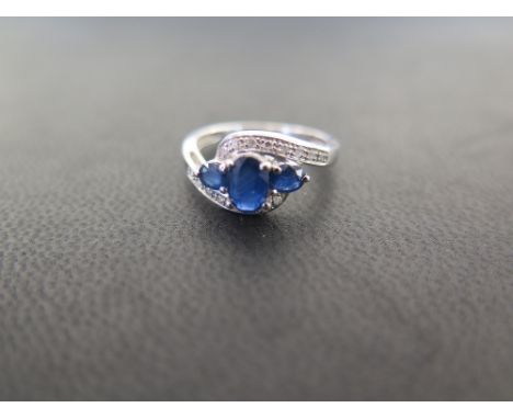 A 9ct gold sapphire and diamond crossover style cluster dress ring - Hallmarked Birmingham - Ring size K 1/2 - Weight approx 