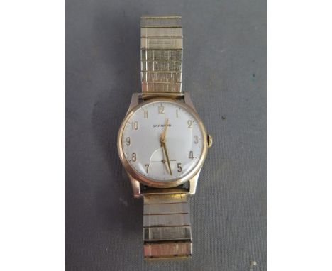 A Gents Garrards 9 ct gold presentation manual wind wristwatch with sprung plated strap, 35 mm wide including winder - stampe