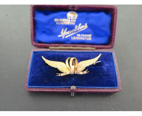 A late 19th/early 20th century 15ct gold bar brooch - Designed as a ribbon to the textured wings - Length 4.5cms - Weight app