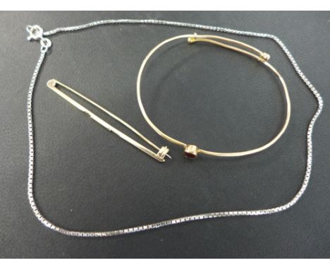 An unmarked rose gold wire bangle set with an oval red stone - tests as 9 or 10 carat and a damaged 9 ct gold bar brooch - We