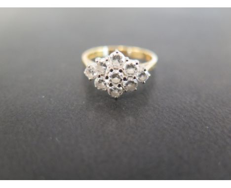 An 18ct gold diamond cluster ring - the brilliant-cut diamonds to the tapered shoulders and plain band - Estimated total diam