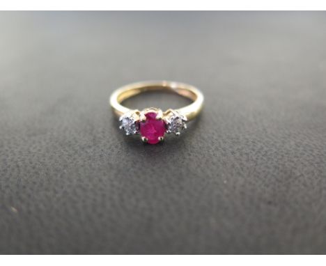 A 9ct gold ruby and diamond dress ring - The oval ruby to the single-cut diamond clusters - Hallmarked Birmingham - Ring size