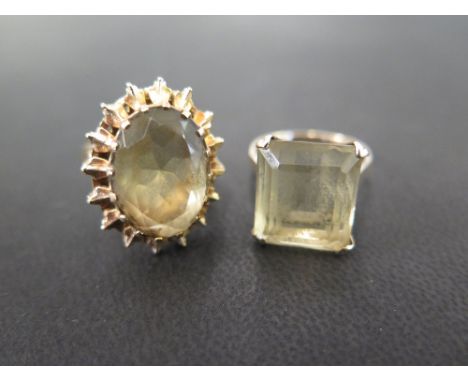 Two 9 ct gold dress rings - one with a large claw set rectangular step cut stone, the second with an oval cut ring with sunbu