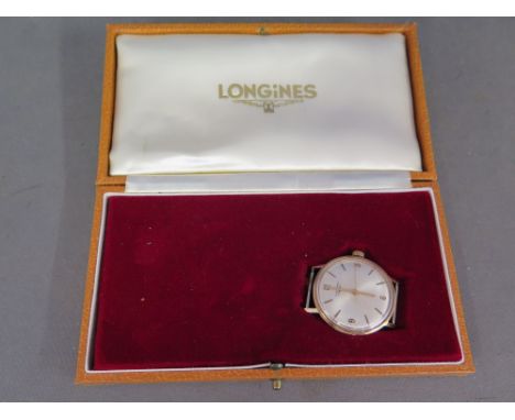 A Gents 9 ct gold Longines wristwatch with pearl face baton markers and Arabic numerals, central second sweep - in original b
