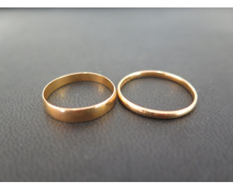 Two 22ct gold band rings - Hallmarked London - Ring sizes R and V - Weight approx 4.4gms
Condition Report: Fair - With dents 