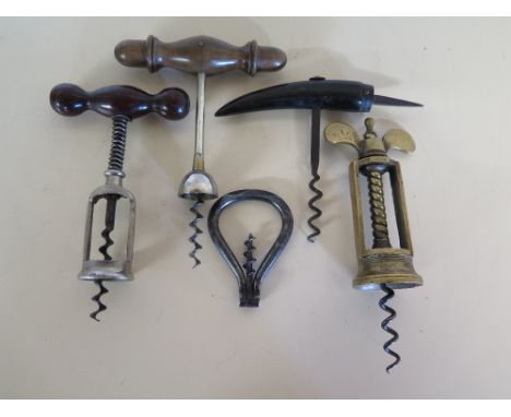 A vintage brass corkscrew, a metal folding corkscrew, two wooden handled corkscrews and a horn handled corkscrew with spike t