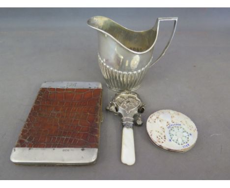 A silver and crocodile skin card case, a silver embossed babies rattle and mother of pearl teether, a silver and pierced moth