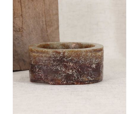 A Chinese jade cong,of short cylindrical square section, each corner worked with an animal mask, the four corners divided by 