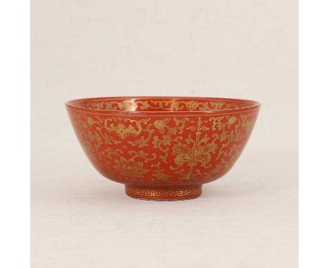 A Chinese coral-glazed bowl,Daoguang (1821-1850), the rounded sides rising from a circular foot, painted with bats among scro