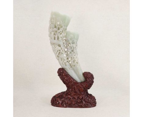 A Chinese jade carving,20th century, in the form of a rhinoceros horn, pierced and carved with a Daoist Immortal with an atte
