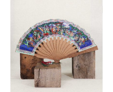 A Chinese boxwood brisé fan,19th century, the guards carved with figures under trees in a garden, the splines similarly decor
