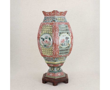 A Chinese famille verte lantern and stand,19th century, of hexagonal form with reticulated panels, each side decorated with a