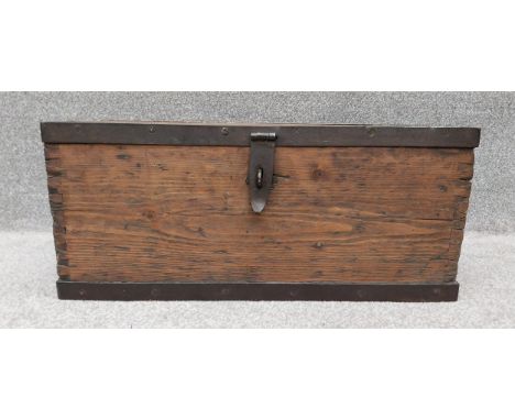 A vintage distressed pine trunk/chest with iron strap-work to the lid and base, with heavy ironwork hinges and latch. H.29 W.
