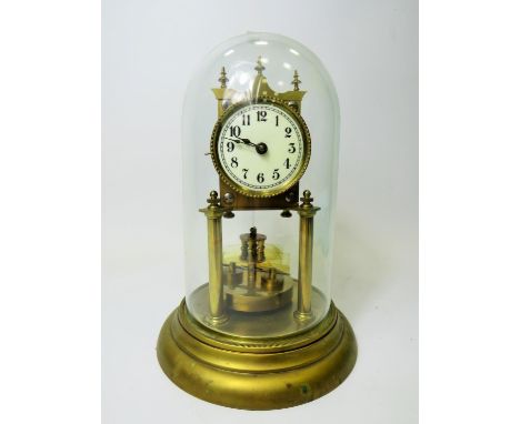 German made brass Anniversary clock under Glass dome. Appears to be in running order.  Small piece missing on the base of the