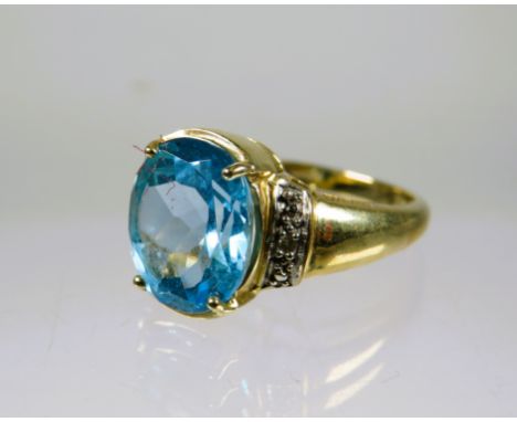 9ct Yellow Gold Ring set with a lovely large Topaz which measures 12 x 8 mm with melee Diamonds to the shoulders.  Finger siz