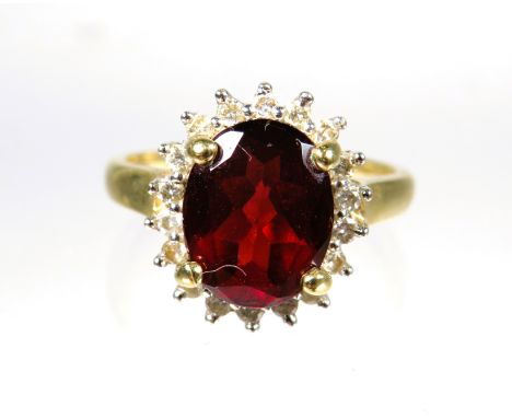 9ct Yellow Gold ring set with a large Oval Garnet which measures approx 10 x 8 mm with Diamond Surround.  Finger size 'M'    