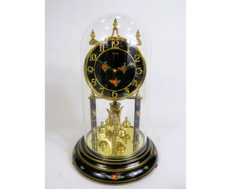 Kunzle German made anniversary clock with black faced dial painted with flowers and matching supports.  Sits under perspex do