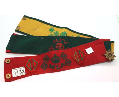 Three believed original British WWII Womens Land Army felt armbands, with a proficiency badge. One armband with moth damage. 