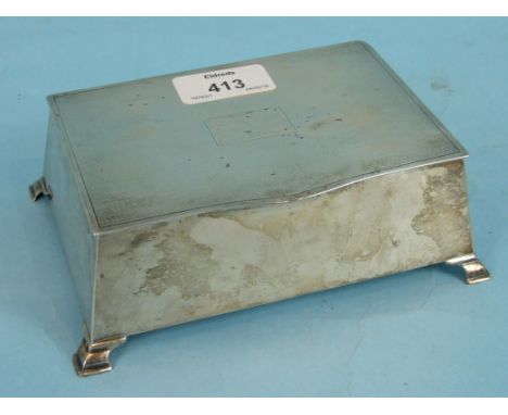 A silver cigarette case of canted rectangular form on bracket feet with engine-turned lid, 16 x 11cm, Birmingham, 1947.