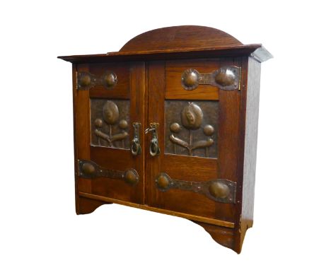 An Arts and Crafts Shapland and Petter of Barnstaple oak wall Cabinet, with oxidised copper and brass mounts, having a domed 