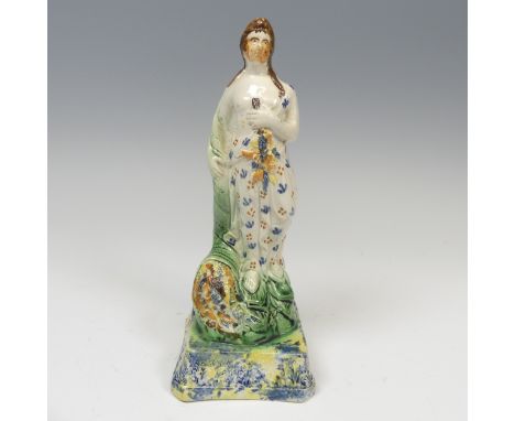 An early 19thC pearlware figure of Spring, decorated in prattware palette, modelled in typical stance raised on spongued base