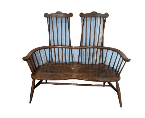 A double Windsor comb back Settle / Bench, comb stick back above shaped seats, raised on four turned legs, W 127 cm x H 119.5