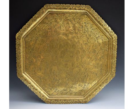 A large Indian brass octagonal charger, profusely chased with a temple, deities, figures and portrait roundels, amongst leafy