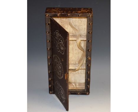 An Arts and Crafts 'antiquarian salvage' rectangular playing card box, tooled leather cover with a foliate mask flanked by ac