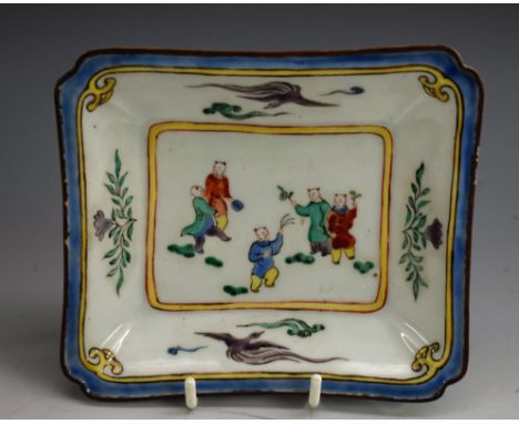 A Chinese shaped rectangular dish, painted in polychrome with boys playing, the border with phoenix and flowers, 14cm wide, f
