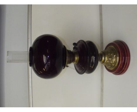 Art nouveau ruby glass oil lamp with brass repousse decoration, height 67cm