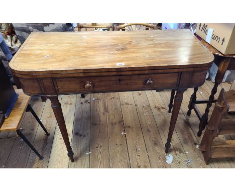 A 1.02m 19th Century mahogany and ebony strung fold-over tea table with long frieze drawer and double gated action, set on tu