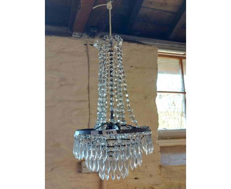 A cut glass waterfall style chandelier with decorative glass ceiling rose and central brass stem surrounded by cascading face