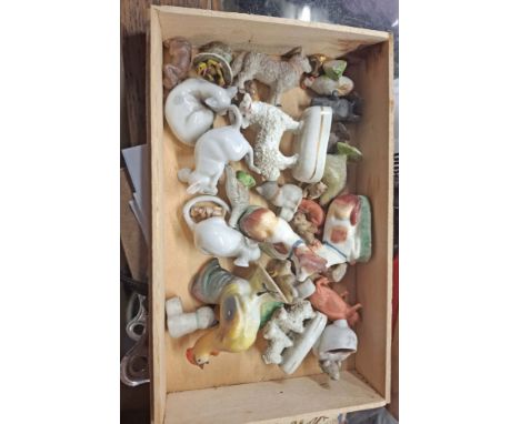 A wooden cigar box containing a collection of miniature ceramic and other animal figurines