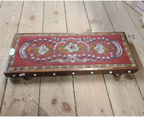 A late Victorian Gothic Revival rosewood veneered stand with decorative beadwork to top and ceramic cabochons and brass mount