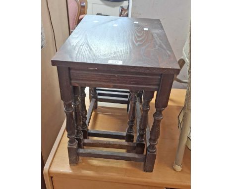 A vintage oak nest of three tea tables, set on turned supports