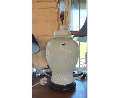 A modern white glazed ceramic table lamp of lidded jar form, set on wooden stand