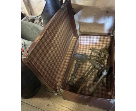 An old suitcase containing a quantity of metalware including a pair of brass fire dogs, pewter candlesticks, etc.