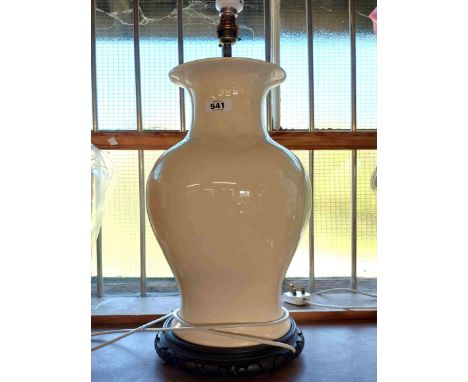 A large modern Chinese ceramic table lamp of baluster form with cream glaze, set on hardwood stand