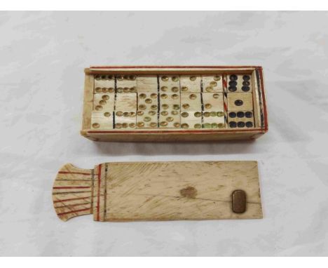A set of antique carved and stained bone dominoes in original slide-top box