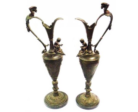 A pair of large 19th Century spelter vases of urn form with cast decoration, depicting cavorting putti and caryatid handles -