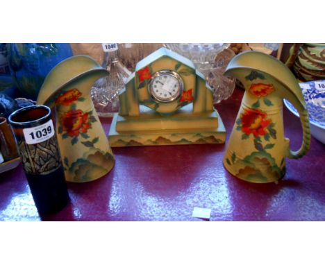 An Art Deco pottery garniture set with cellulose finish decoration comprising a clock and two jugs - sold with a Celtic potte