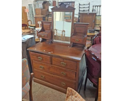 A 1.04m Edwardian stained walnut dressing chest with bevelled oblong swing mirror and flanking trinket drawers, over a base w