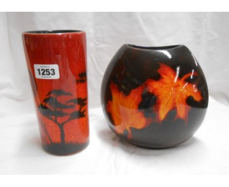 A Poole Pottery vase with hand painted decoration, depicting a tree silhouetted against a fiery sun on an orange glaze ground