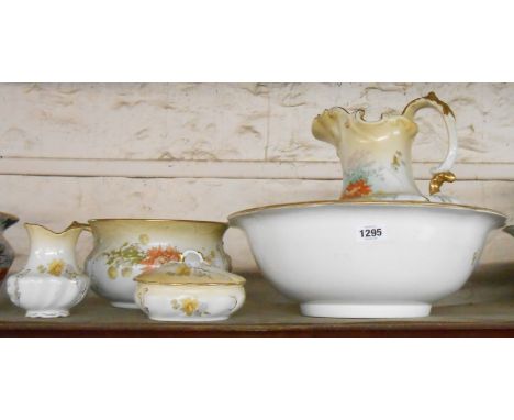A Royal Doulton toilet set with floral decoration on a blush ground, comprising jug, bowl, chamber pot, toothbrush holder and